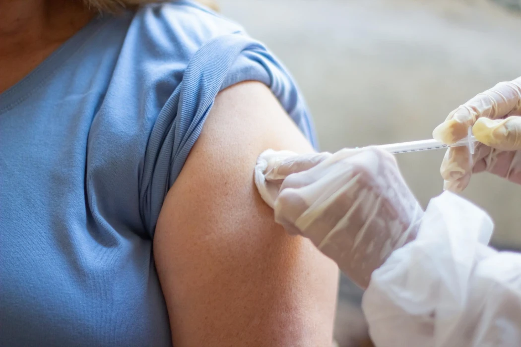 Close-up of nurse hands vaccinating patient with syringe. Doctor injecting patient upper arm. Medicine, vaccination, immunization, healthcare concept